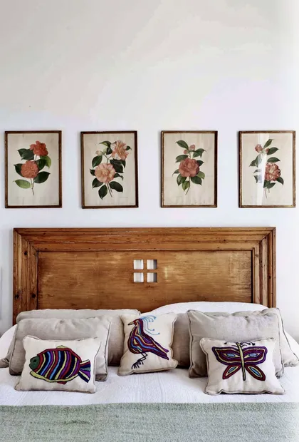 Dormitorio con cabecera de madera y cuadros florales botánicos — proyecto Lagos del Norte, por Marconi Silva Arquitectos, en Don Torcuato