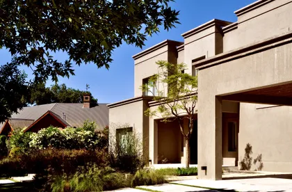 Casa contemporánea con fachada beige, pergolados y jardín integrado — proyecto Martindale Country Club, por Marconi Silva Arquitectos, en Pilar