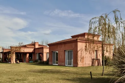 Casa de ladrillo terracota con galeria, jardin y sauce llorón — proyecto San Francisco 1, por Marconi Silva Arquitectos, en Manzanares