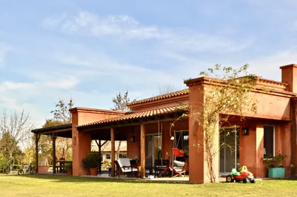 Casa campo con galería cubierta ladrillo visto y jardín verde — proyecto San Francisco 1, por Marconi Silva Arquitectos, en Manzanares