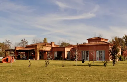 Casa de campo moderna con fachada terracota y jardín amplio — proyecto San Francisco 1, por Marconi Silva Arquitectos, en Manzanares