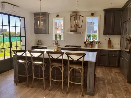 Cocina moderna con isla central y banquetas altas de madera — proyecto San Matías, por Marconi Silva Arquitectos, en Belén de Escobar