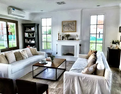 Living moderno con sillones beige y mesa de centro de madera — proyecto San Matías, por Marconi Silva Arquitectos, en Belén de Escobar