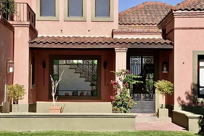 Casa de estilo mediterráneo con fachada color terracota y ventanales — proyecto Valle Claro, por Marconi Silva Arquitectos, en Benavidez