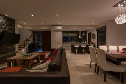 Living comedor cocina moderno, isla, sofá modular, mesa de madera — proyecto Costa Esmeralda 1, por Arquitecto Caceres, en Costa Esmeralda