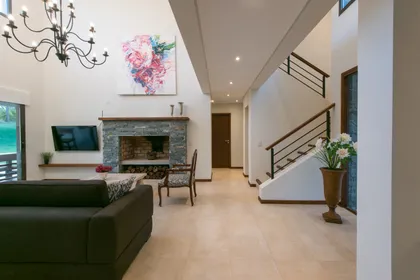 Living moderno de doble altura con escalera flotante — proyecto Costa Esmeralda 2, por Arquitecto Caceres, en Costa Esmeralda