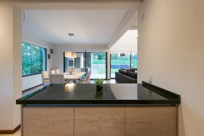 Cocina moderna con isla, comedor y living integrados, vista amplia — proyecto Costa Esmeralda 2, por Arquitecto Caceres, en Costa Esmeralda