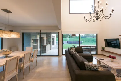 Living comedor moderno con cocina integrada y araña negra — proyecto Costa Esmeralda 2, por Arquitecto Caceres, en Costa Esmeralda