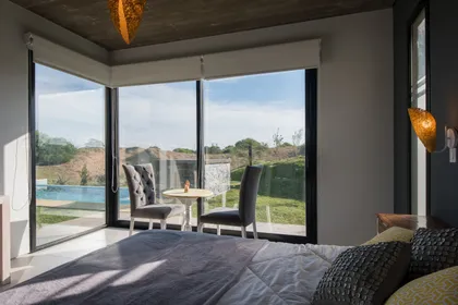 Dormitorio moderno con vista a campo y luz natural abundante — proyecto Costa Esmeralda 3, por Arquitecto Caceres, en Costa Esmeralda