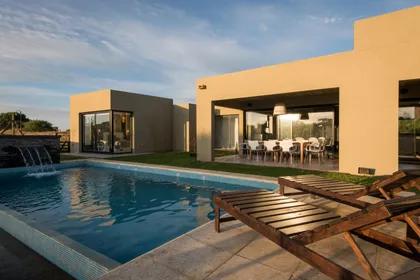 Casa moderna con pileta y deck de madera estilo mediterráneo — proyecto Costa Esmeralda 3, por Arquitecto Caceres, en Costa Esmeralda