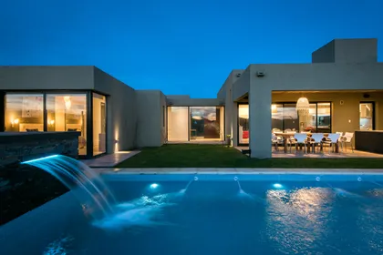 Casa moderna con piscina y patio cubierto al atardecer — proyecto Costa Esmeralda 3, por Arquitecto Caceres, en Costa Esmeralda