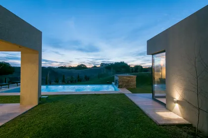 piscina moderna minimalista al atardecer con luces cálidas — proyecto Costa Esmeralda 3, por Arquitecto Caceres, en Costa Esmeralda