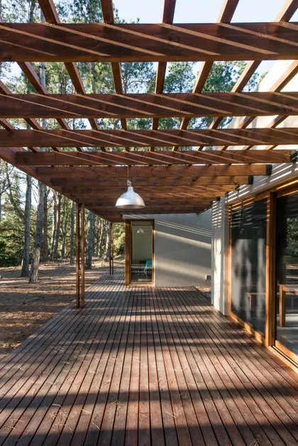 Terraza de madera y pérgola de madera en entorno de bosque — proyecto Costa Esmeralda Casa MAI Lote 374 Deportiva, por Arquitecto Caceres, en Costa Esmeralda