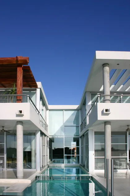 Casa moderna con patio central y piscina, amplias ventanas de vidrio y pérgola de madera — proyecto Casa Hormigon, por Barrionuevo Arquitects, en B1648 Tigre