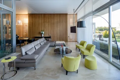 Living moderno con sofá modular gris y sillones curvos color lima — proyecto Casa Pez, por Barrionuevo Arquitects, en B1648 Tigre