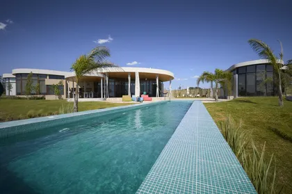 Casa moderna con piscina infinita y arquitectura curva — proyecto Casa Petalo, por Barrionuevo Arquitects, en Punta del Este