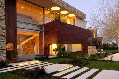 fachada moderna de casa con madera oscura y grandes ventanales — proyecto Casa Cardales, por Barrionuevo Arquitects, en Los Cardales