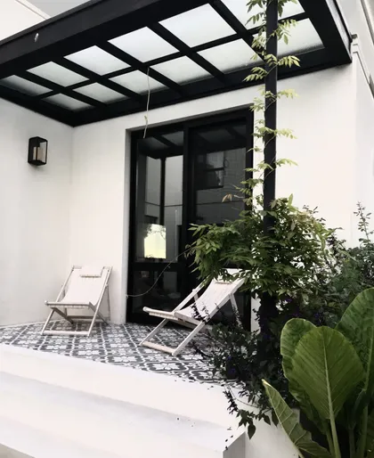 Patio moderno con suelo estampado y sillas de lona blancas — proyecto Barrio Mayling, por Estudio Moreto Bensusan, en Pilar