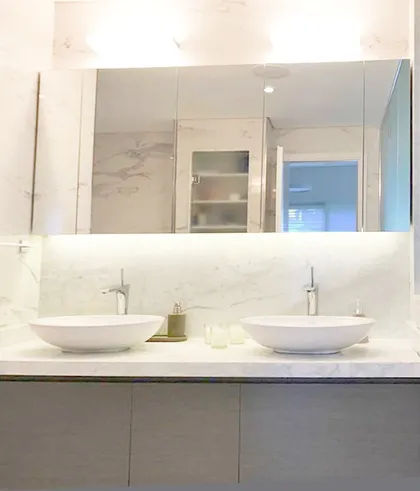 baño moderno con doble vanitory y espejo empotrado — proyecto Reforma Belgrano R, por Estudio Moreto Bensusan, en Belgrano R