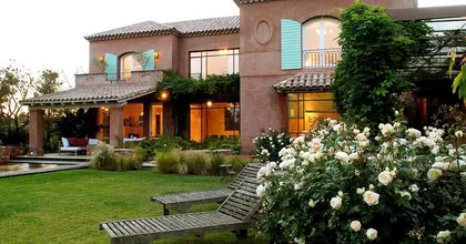 fachada de casa mediterránea con jardín frondoso — proyecto Laguna del Sol, por Estudio Moreto Bensusan, en Tigre