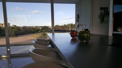 Cocina moderna minimalista con isla y vista al campo — proyecto Costa Esmeralda, por Cuello Selva, en Costa Esmeralda