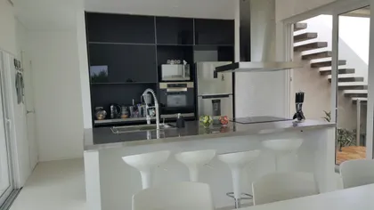 Cocina moderna integrada con isla y barra, estufas de acero inox — proyecto Costa Esmeralda, por Cuello Selva, en Costa Esmeralda
