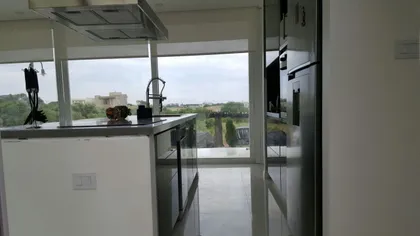 Cocina moderna con isla de mármol y vista a la ciudad — proyecto Costa Esmeralda, por Cuello Selva, en Costa Esmeralda