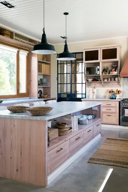 Cocina rústica con gran isla central y mucha madera natural — proyecto Santa María de Lobos, por Estudio Magrane, en Lobos