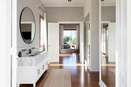 Baño moderno con mesada de mármol y ventanal amplio — proyecto Santa María de Lobos, por Estudio Magrane, en Lobos