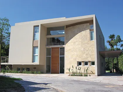 Fachada moderna residencial con piedra y vidrio a doble altura — proyecto Casa en San Isidro, por GEN STUDIO COMOTTO - SOMMER , en San Isidro