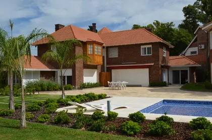 Casa mediterránea con fachada de ladrillo y piscina en suburbio — proyecto Casa en Barrio El Jockey - San Isidro, por GEN STUDIO COMOTTO - SOMMER , en San Isidro