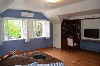 Dormitorio moderno con grandes ventanales y vistas verdes — proyecto Casa en Barrio El Jockey - San Isidro, por GEN STUDIO COMOTTO - SOMMER , en San Isidro