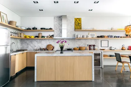 Cocina moderna con isla de madera, mesada de mármol y estantes flotantes — proyecto Belgrano, por Estudio Magrane, en Belgrano