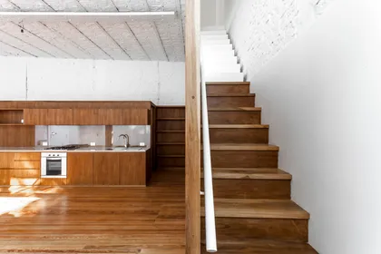 Cocina moderna con escalera flotante y techo de hormigón expuesto — proyecto PH Tamborini , por ariana werber arquitecta, en Núñez