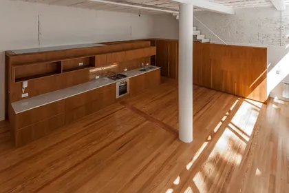 Cocina moderna con doble altura y revestimiento en madera — proyecto PH Tamborini , por ariana werber arquitecta, en Núñez