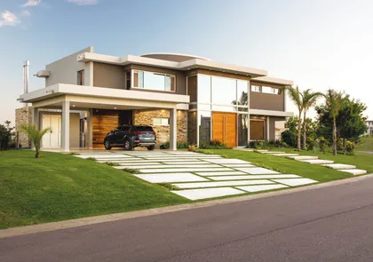 Fachada moderna de casa suburbana con contraste de hormigón y madera — proyecto La Reserva Cardales I, por ARQCONS, en Los Cardales