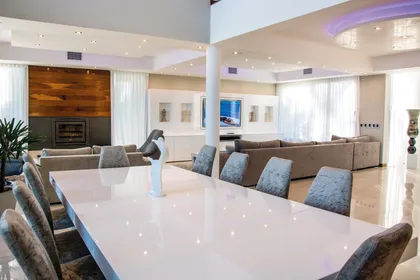 Living comedor moderno con paredes de madera y ventanales amplios — proyecto La Reserva Cardales I, por ARQCONS, en Los Cardales