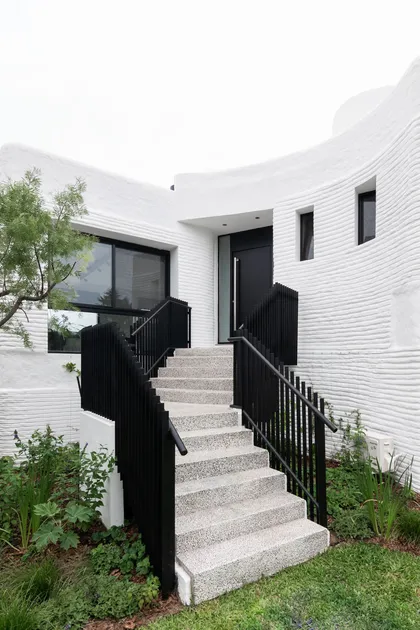 Fachada moderna con muros curvos texturizados y escaleras flotantes — proyecto Boating I, por Estudio Arq. Ana M. Carrera, en Boating Club