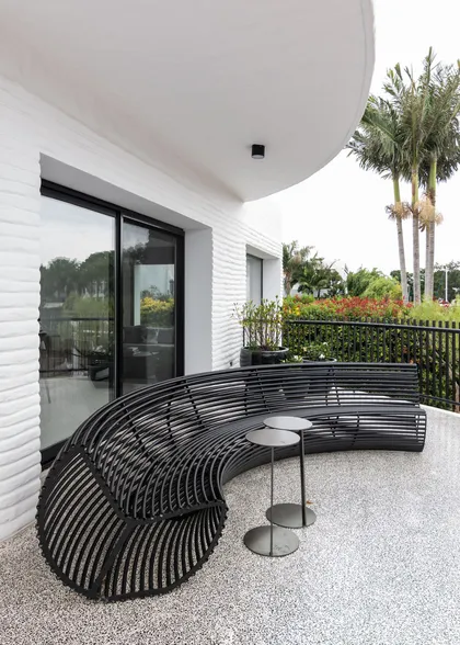 Terraza moderna con sofá curvo negro y pared de ladrillo blanco texturizado — proyecto Boating I, por Estudio Arq. Ana M. Carrera, en Boating Club