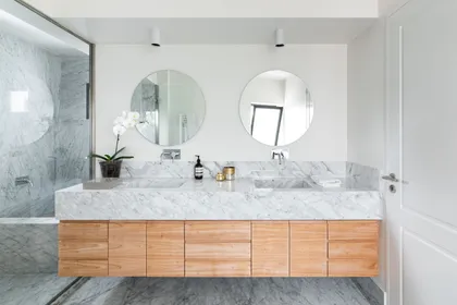 Baño moderno con doble vanitory, mármol y madera flotante — proyecto Boating I, por Estudio Arq. Ana M. Carrera, en Boating Club