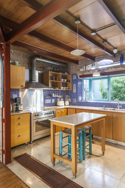 Cocina industrial rústica con vigas de madera y azulejos azules — proyecto Casa Warnes, por Silvia Soqueff, en CABA