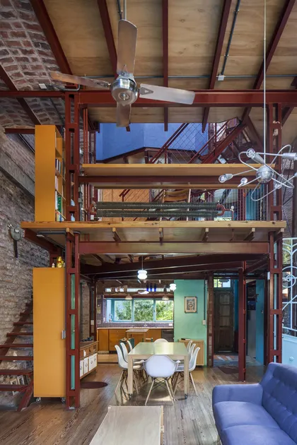 interior industrial multinivel con vigas expuestas y madera natural — proyecto Casa Warnes, por Silvia Soqueff, en CABA