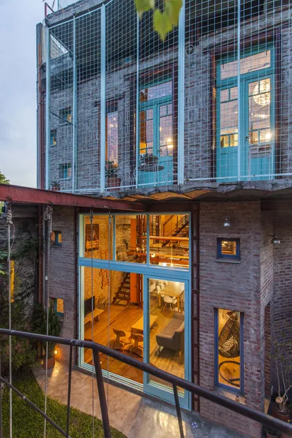 Fachada industrial de ladrillo con amplios ventanales de vidrio y detalles metálicos — proyecto Casa Warnes, por Silvia Soqueff, en CABA