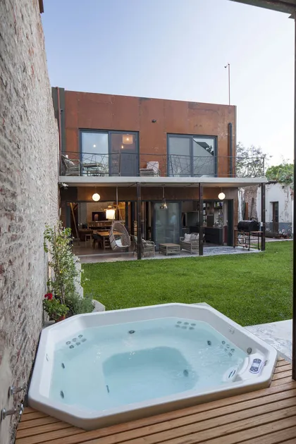 Casa moderna industrial con jacuzzi exterior y césped — proyecto Casa Lavalle, por Silvia Soqueff, en CABA