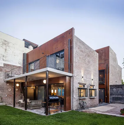Fachada moderna industrial con metal oxidado y ladrillo texturizado — proyecto Casa Lavalle, por Silvia Soqueff, en CABA
