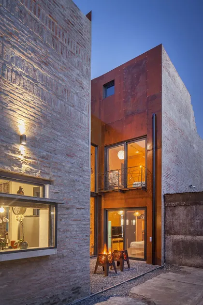 Fachada industrial con fogoneros y ladrillo expuesto — proyecto Casa Lavalle, por Silvia Soqueff, en CABA