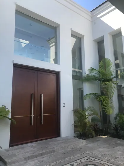 fachada moderna con puertas dobles y grandes ventanales — proyecto San Isidro Labrador, por GreenArq - Carolina Faverio , en San Isidro