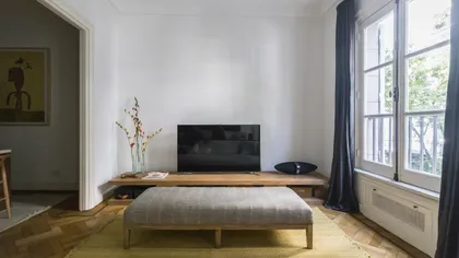 Dormitorio minimalista con cama baja, TV y ventanal luminoso — proyecto Arenales, por BAS Y GARCIA , en Recoleta