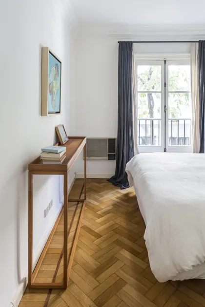 dormitorio minimalista con escritorio de madera y ventanal a balcón — proyecto Arenales, por BAS Y GARCIA , en Recoleta