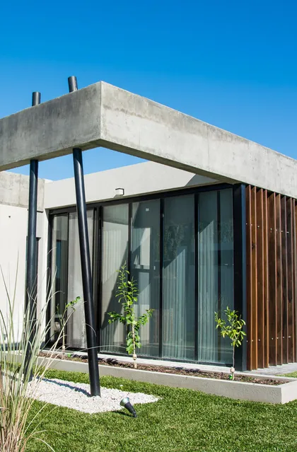 Casa moderna con estructura hormigon, ventanales negros y jardin minimalista — proyecto CASA SI, por DX ARQ